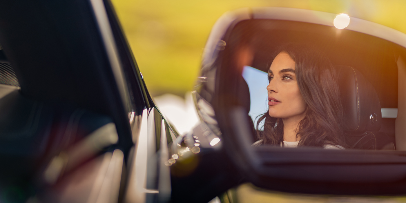 Bentley Polanco profile of dark haired woman's face in mirror of Bentley car in sunlight