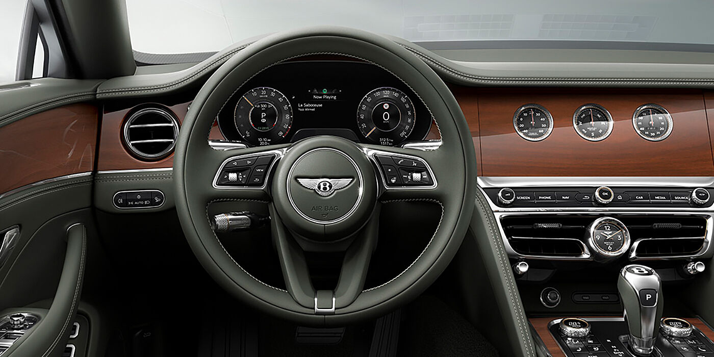 Bentley Polanco New Bentley Flying Spur sedan front cabin in Cumbrian Green hide and Crown Cut walnut veneer showing steering wheel and Rotating Display with three clocks on face