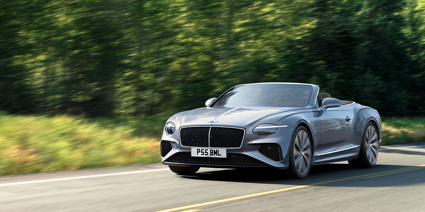 Bentley Polanco New Bentley Continental GTC convertible front view in Silverlake paint with 22 inch ten spoke wheels, driving dynamically on a country road